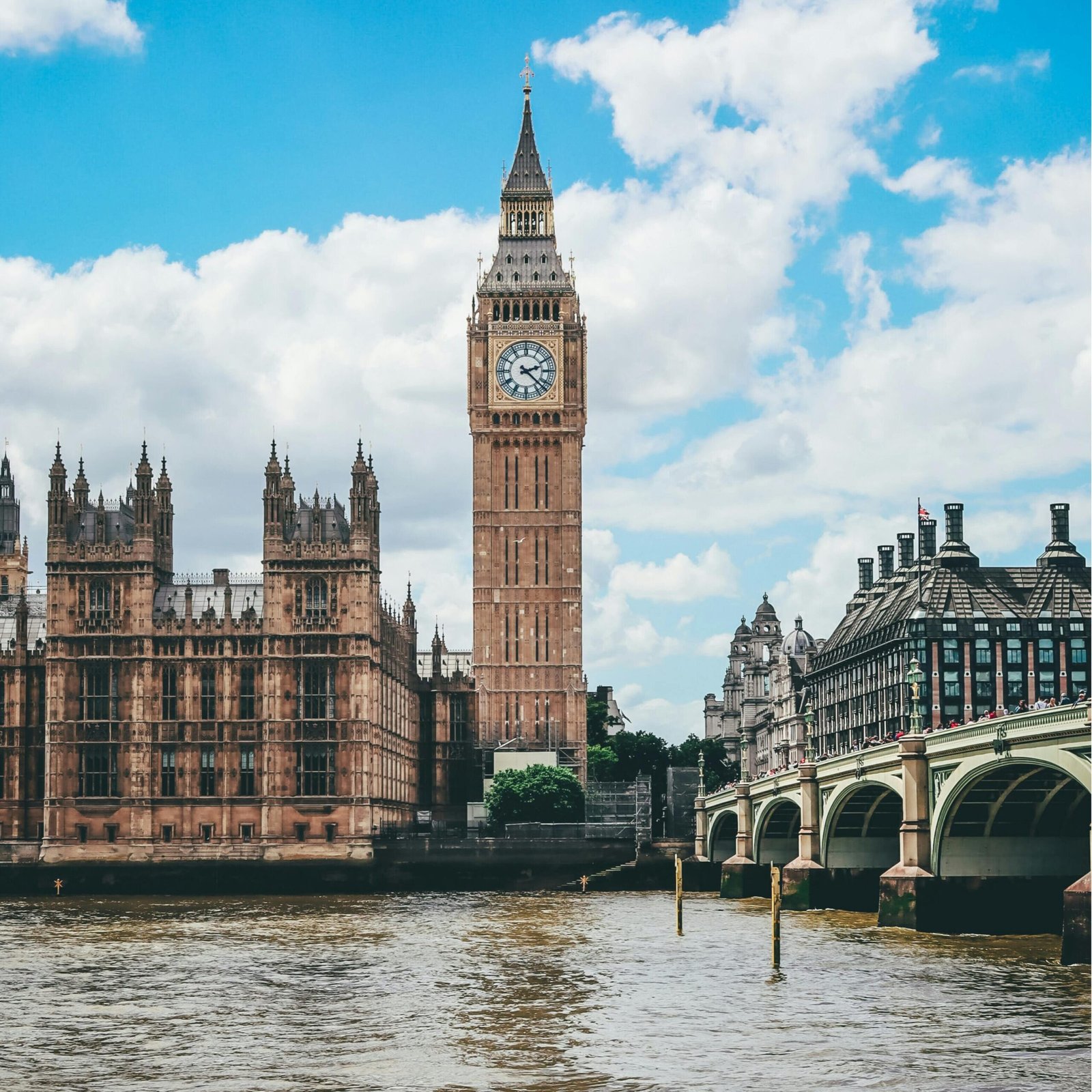 Beautiful view of Big Ben and River Thames under a blue sky in London, England.